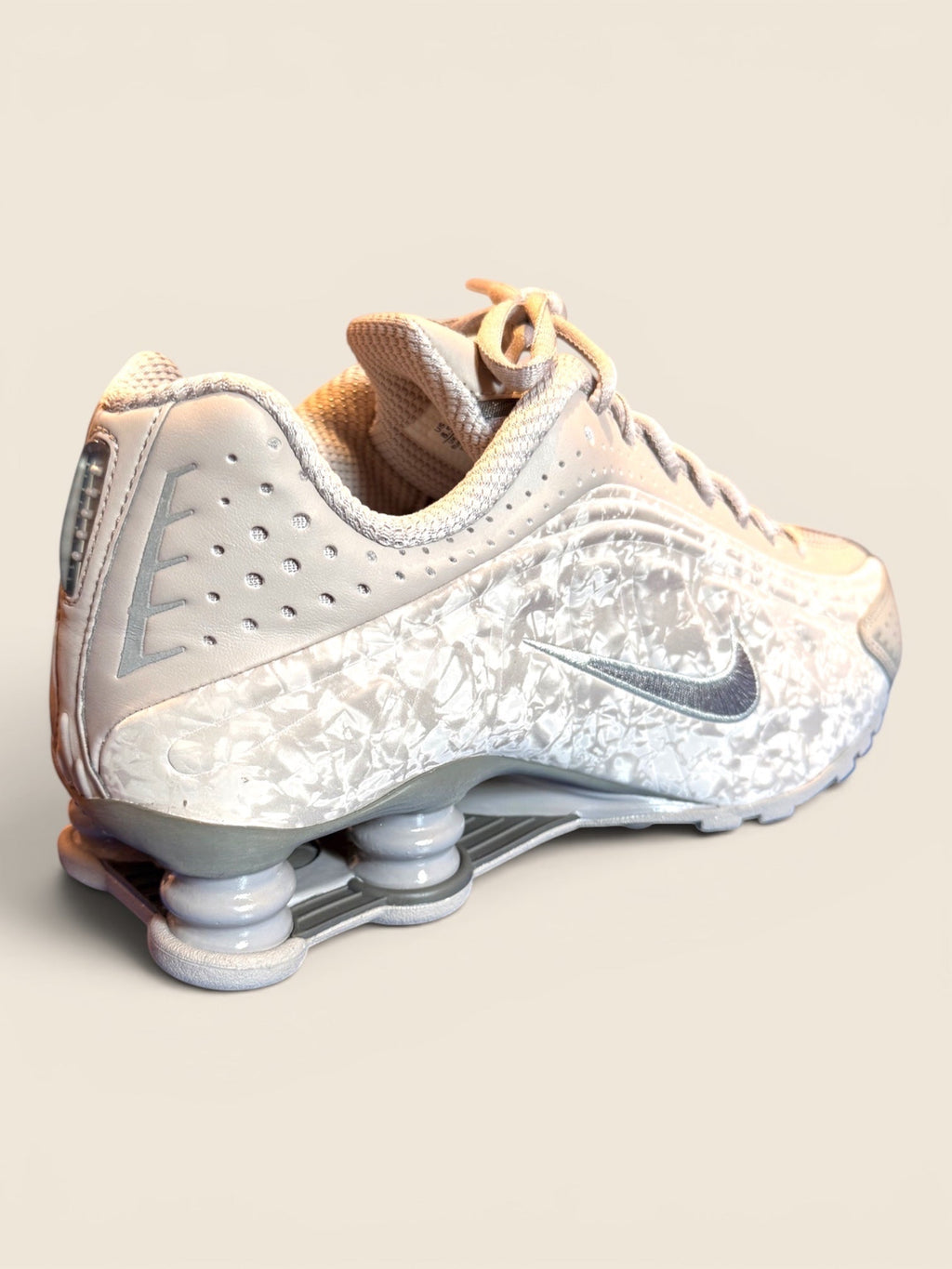 Nike Shox TL Damenschuh in Weiß mit Marmormuster und silbernem Swoosh-Logo. Leder und Mesh.