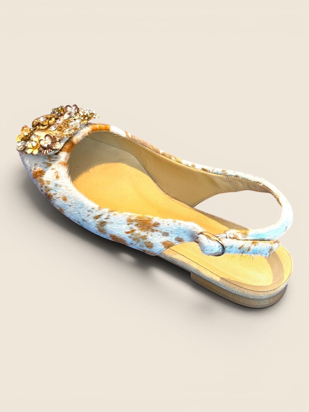 ViCo Unique Potsdam Slingback Ballerinas mit Kuhfell-Muster in Blau und Braun, verziert mit goldenen Blumen-Applikationen.